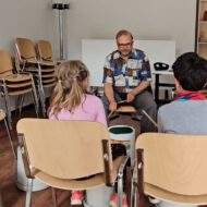 Trommellehrer Mahmoud trommelt mit zwei Kindern.
