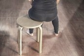Person sitzt auf einem Hocker